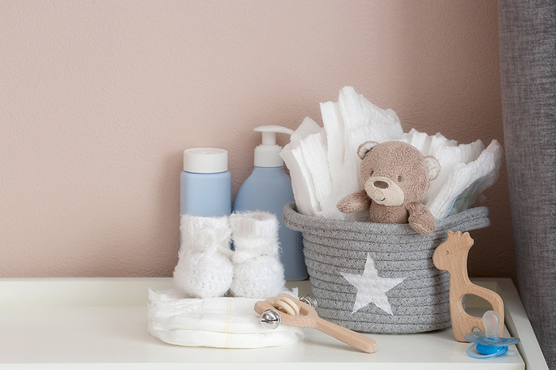 A stack of diapers, booties and baby accessories on a changing t